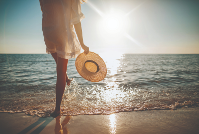 Woman standing on the beach near the ocean shoreline